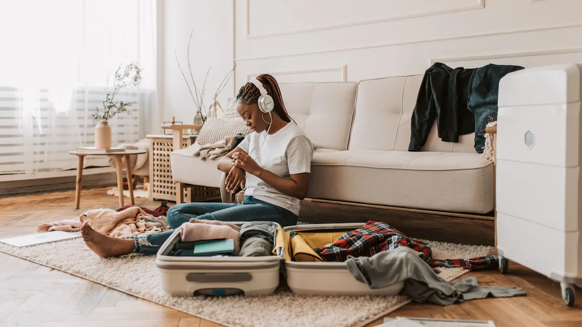 Persona preparando una maleta en casa antes de viajar
