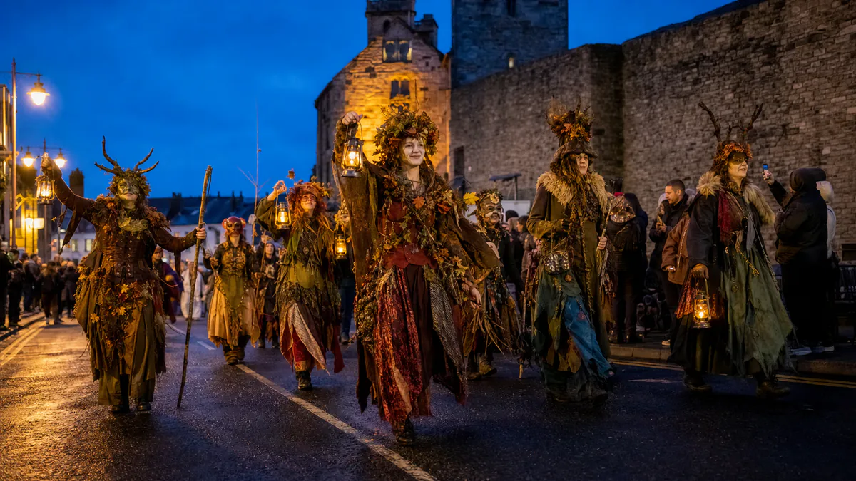 Desfile nocturno ilustrativo junto a unas murallas históricas