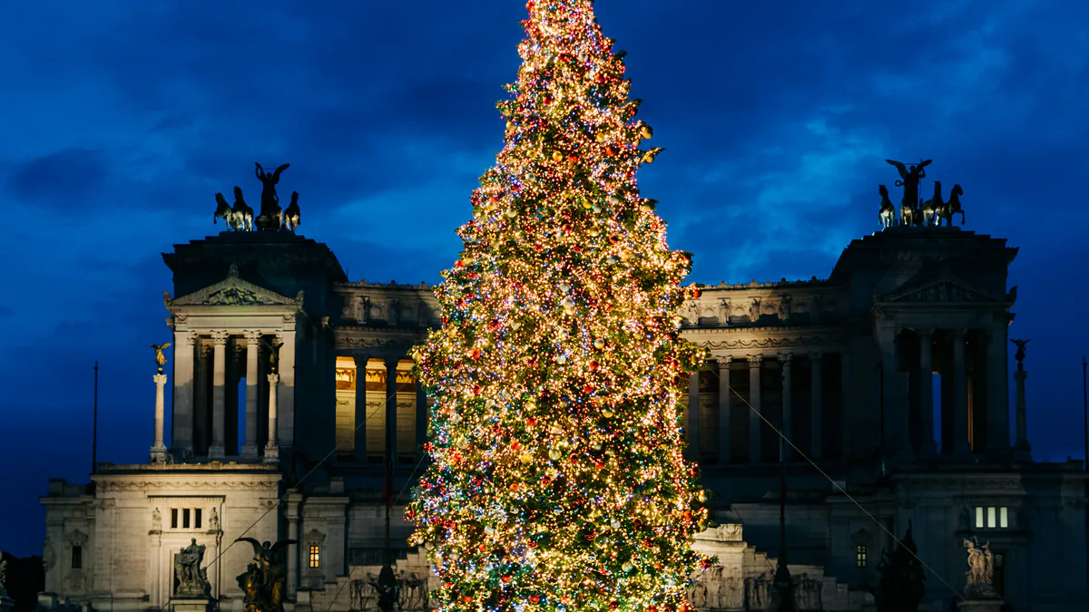 Árbol de Navidad iluminado frente al monumento a Víctor Manuel II en Roma