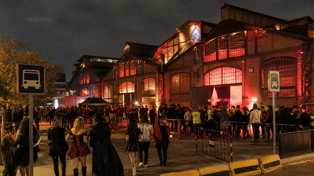 Personas disfrazadas llegando a una fiesta de Halloween en un recinto de Madrid