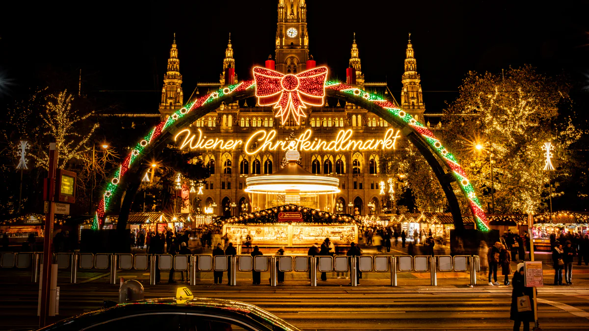 Mercado de Navidad de Rathausplatz iluminado frente al Ayuntamiento de Viena