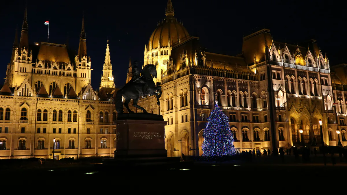 Parlamento de Budapest iluminado junto a un árbol de Navidad